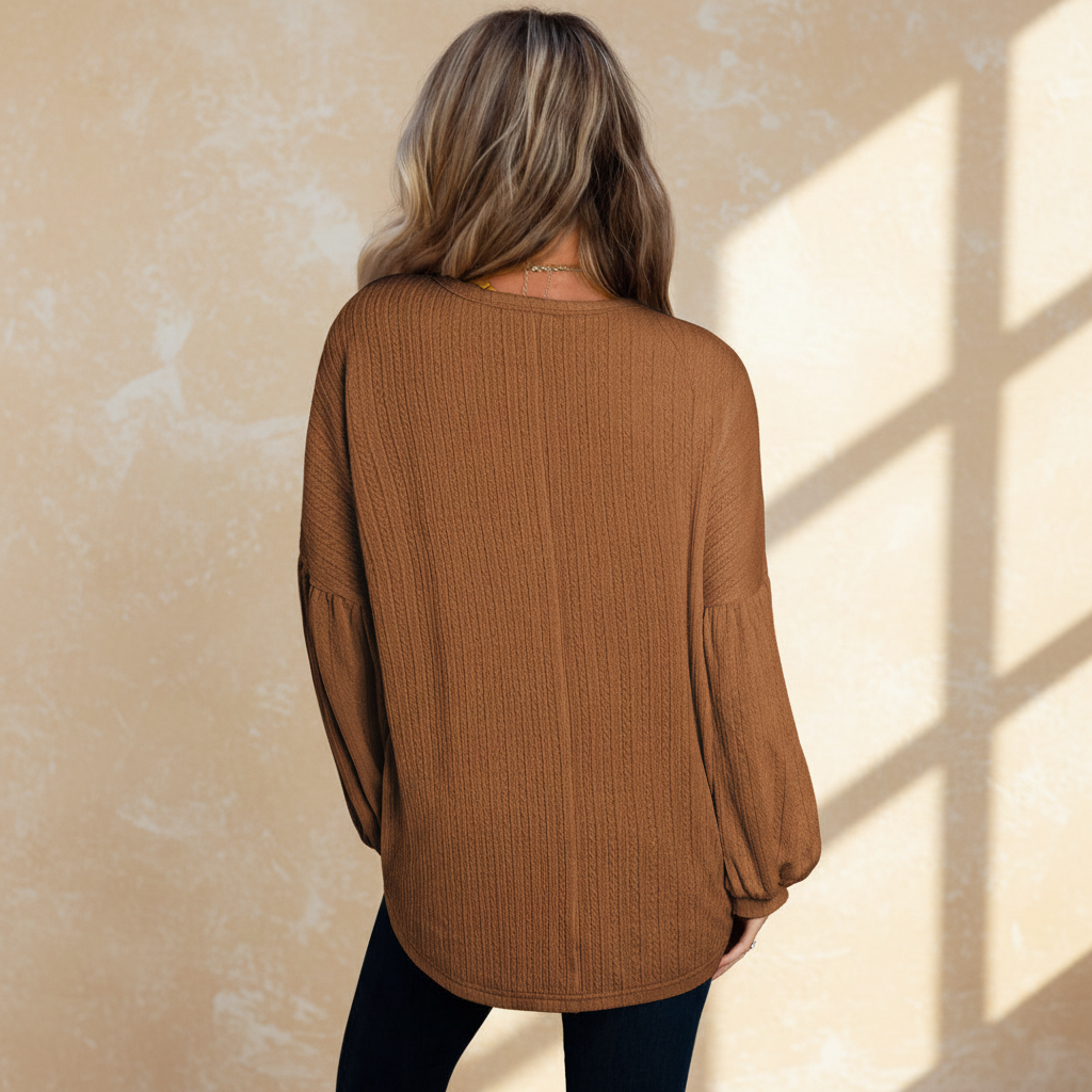 Faux knit jacquard puffy long sleeve top on a warm ivory boutique studio background