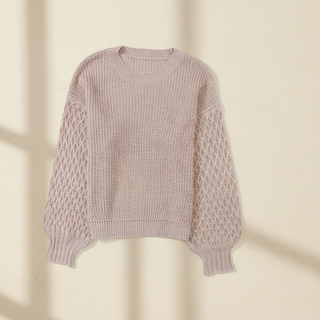 Parchment cable knit sleeve drop shoulder sweater on a warm ivory boutique studio background