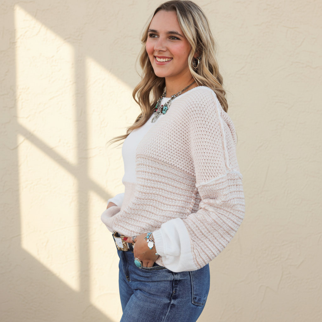 Oatmeal mixed pattern knit tie keyhole drop shoulder sweater on a warm ivory boutique studio background