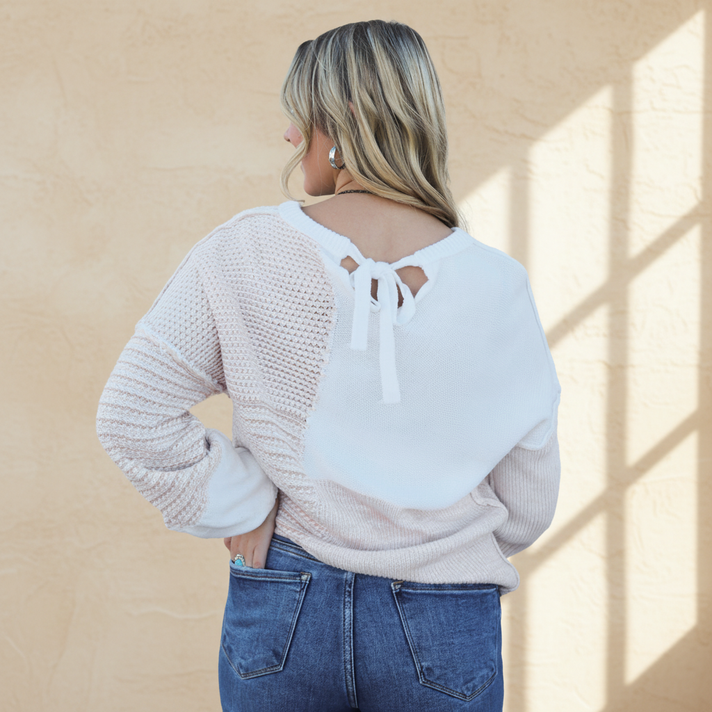Oatmeal mixed pattern knit tie keyhole drop shoulder sweater on a warm ivory boutique studio background