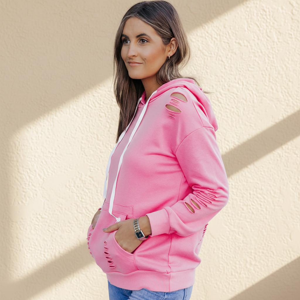 Pink solid ripped hooded sweatshirt with kangaroo pocket on a warm ivory boutique studio background