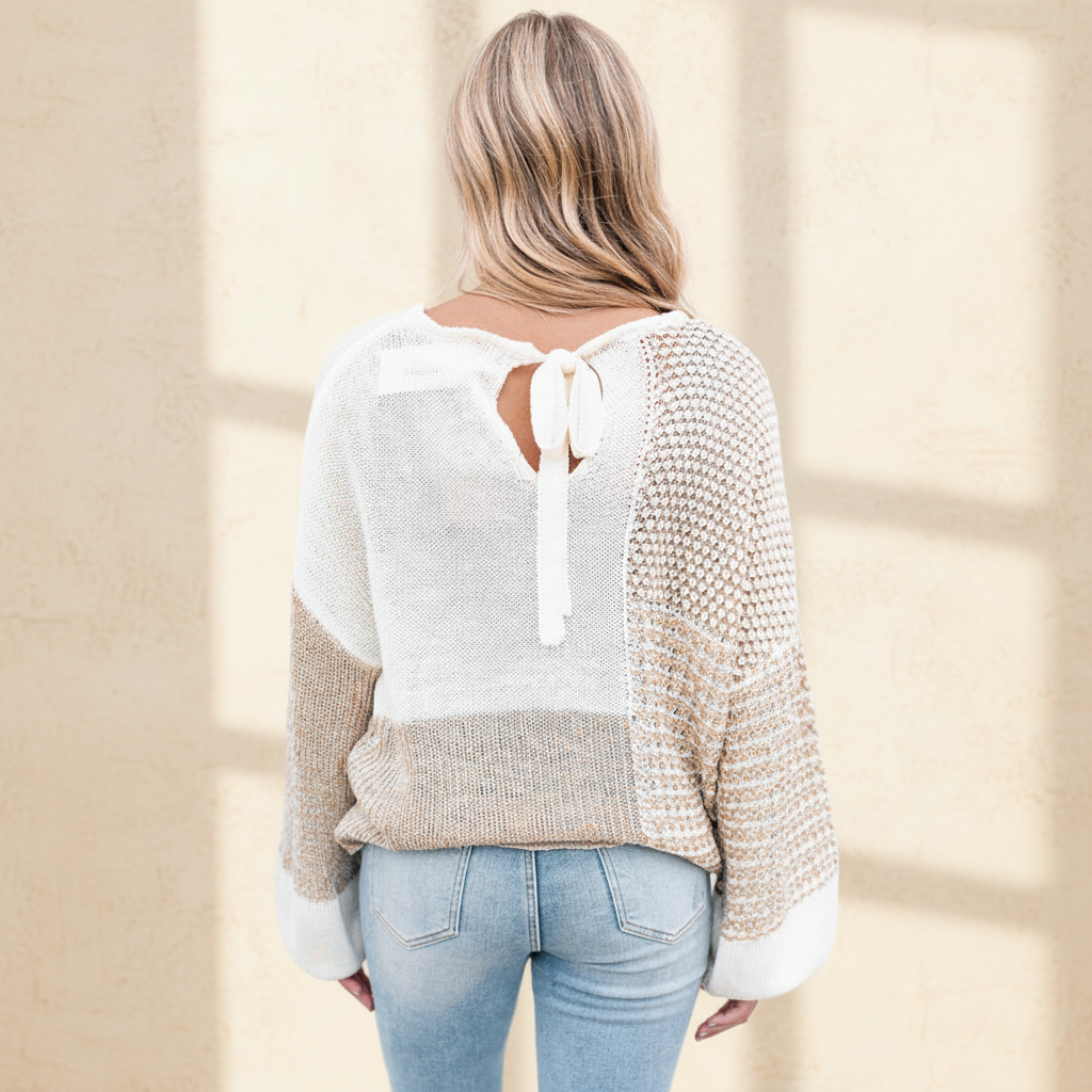 Oatmeal mixed pattern knit tie keyhole drop shoulder sweater on a warm ivory boutique studio background