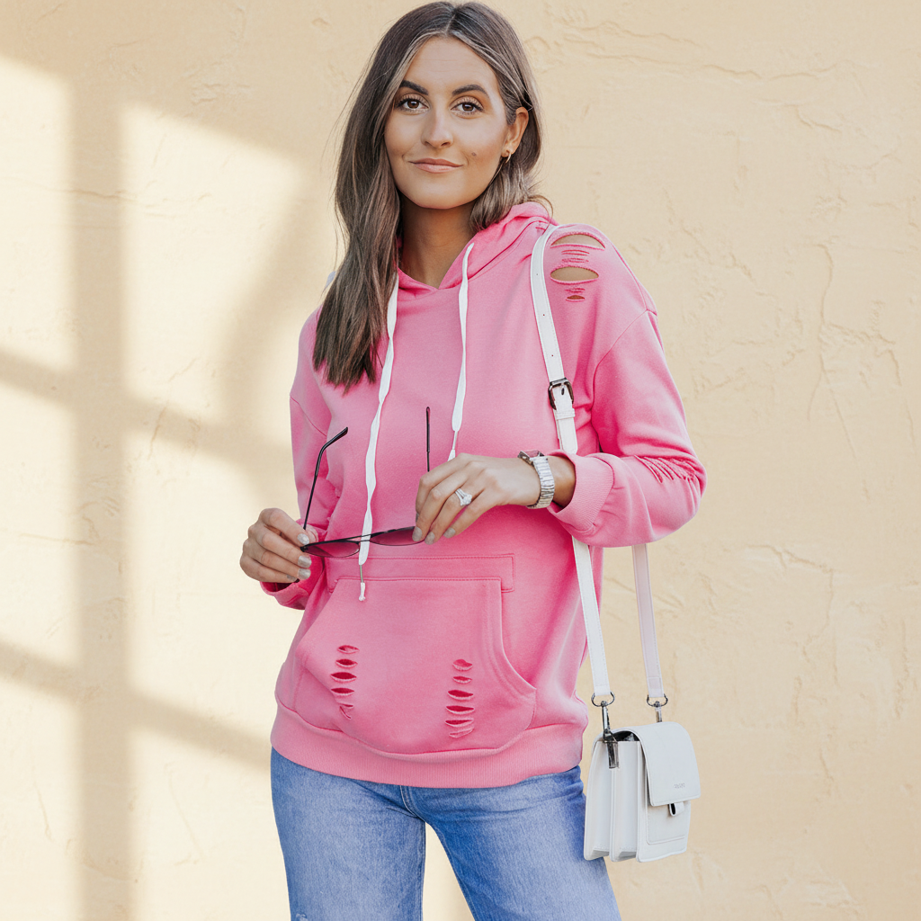 Pink solid ripped hooded sweatshirt with kangaroo pocket on a warm ivory boutique studio background