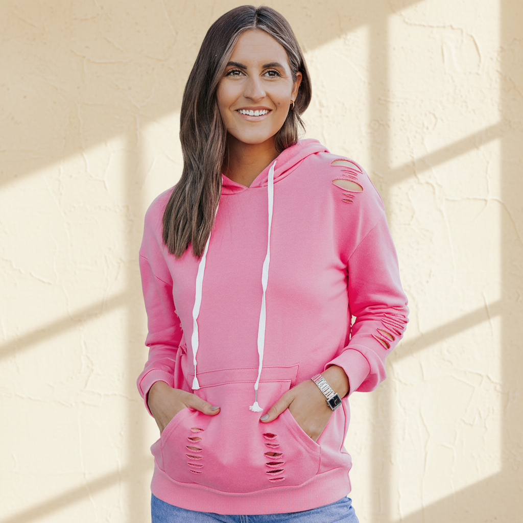 Pink solid ripped hooded sweatshirt with kangaroo pocket on a warm ivory boutique studio background