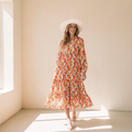 Multicolor boho floral collared long sleeve ruffled dress on a warm ivory boutique studio background