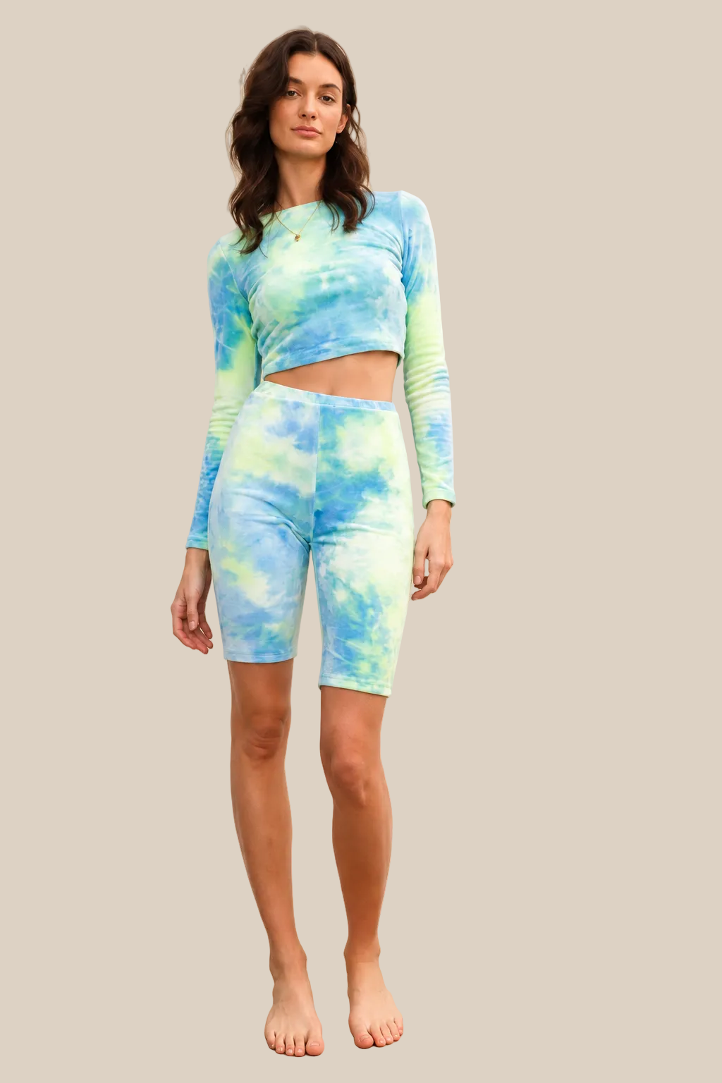 Green multicolor tie-dye velvet cropped long sleeve top and bike shorts set on a warm ivory boutique background, angle 2