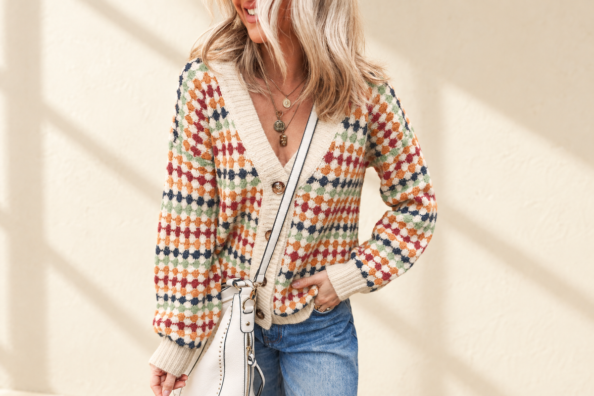 Multicolour dotty pattern knit button-front V-neck sweater cardigan on a warm ivory boutique background, angle 1