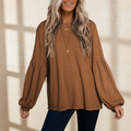 Faux knit jacquard puffy long sleeve top on a warm ivory boutique studio background