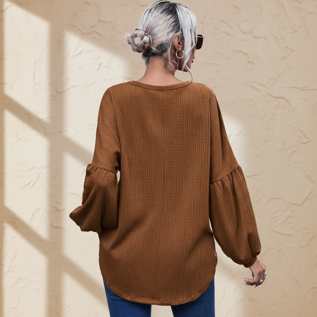 Faux knit jacquard puffy long sleeve top on a warm ivory boutique studio background